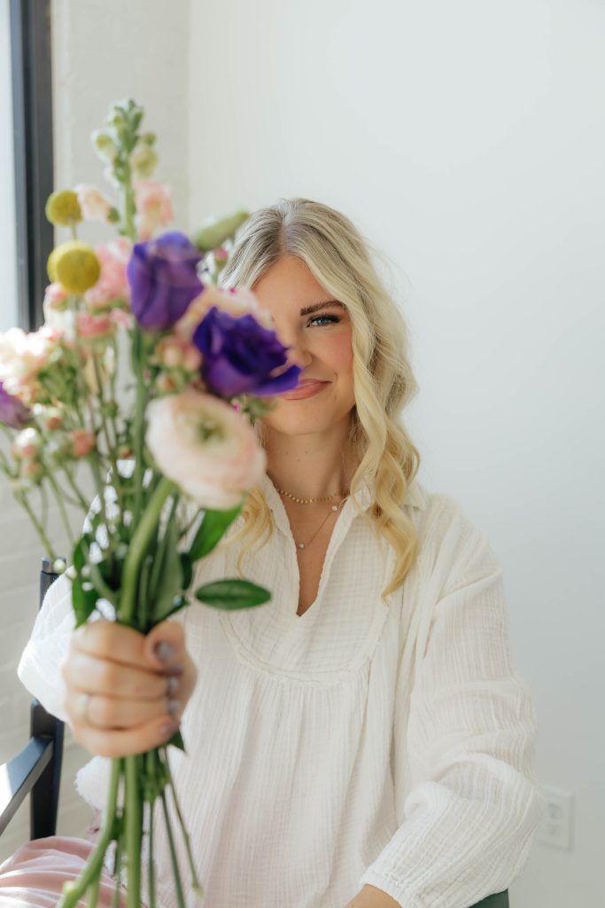 Kloe Brown holding a stem of lisianthus and garden roses