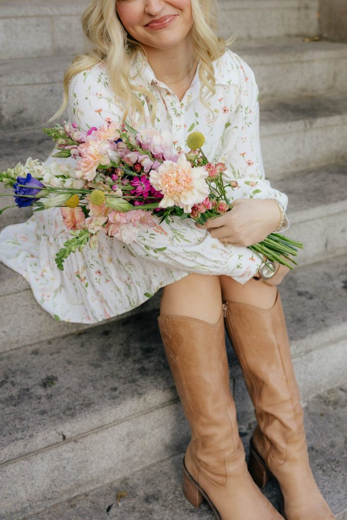 Kloe Brown seated with a pastel hand-tied bouquet