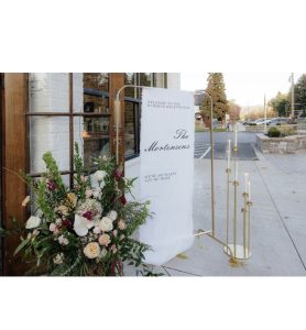 Wedding welcome sign with a floral arrangement at the base