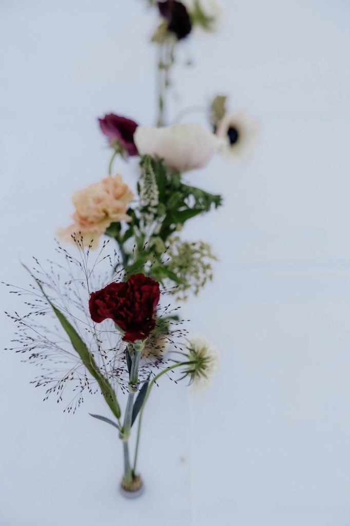 Airy single-stem arrangement with a burgundy rose and ranunculus