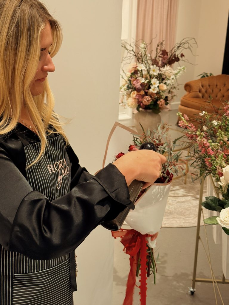 Kloe finishing a wrapped bouquet at a Flora by Klo pop-up