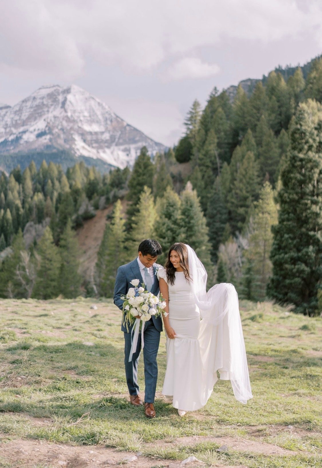 Bride and groom in the mountains with a white bridal bouquet