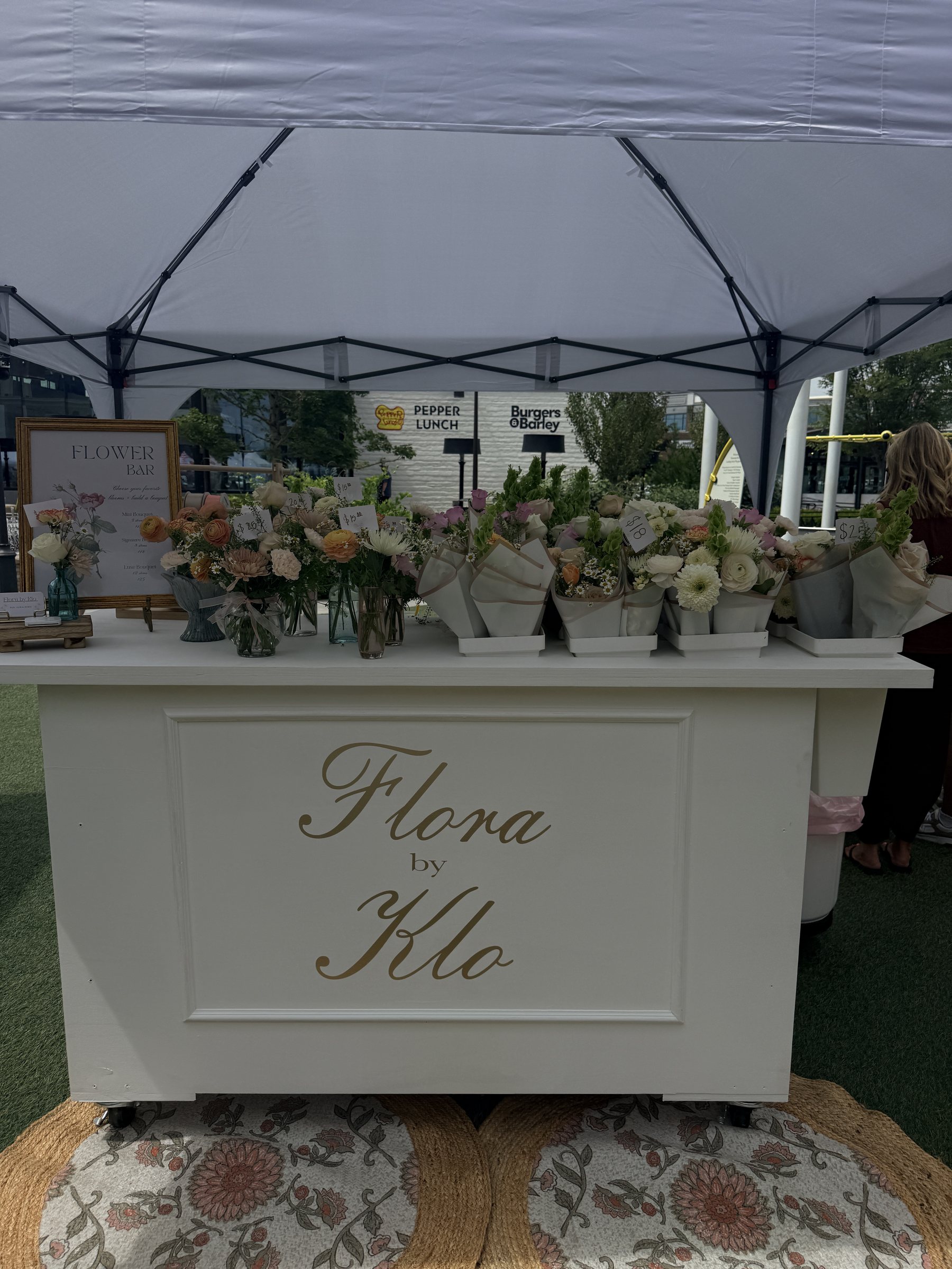 Flora by Klo flower cart filled with fresh bouquets at an outdoor pop-up