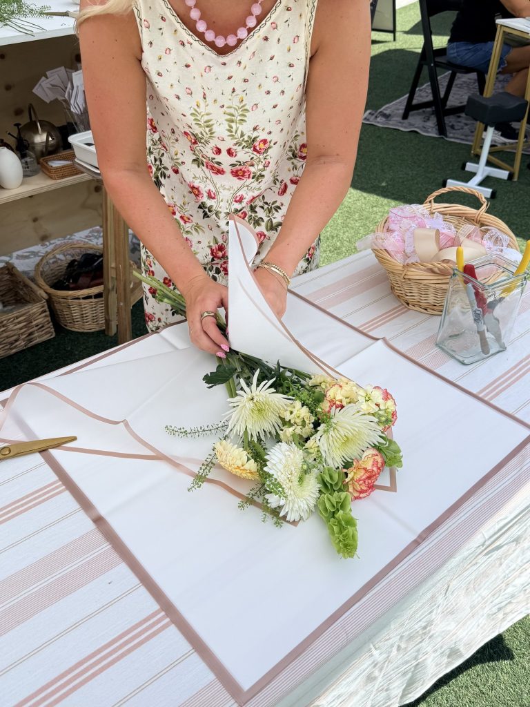 Wrapping a fresh bouquet at a Flora by Klo pop-up flower bar