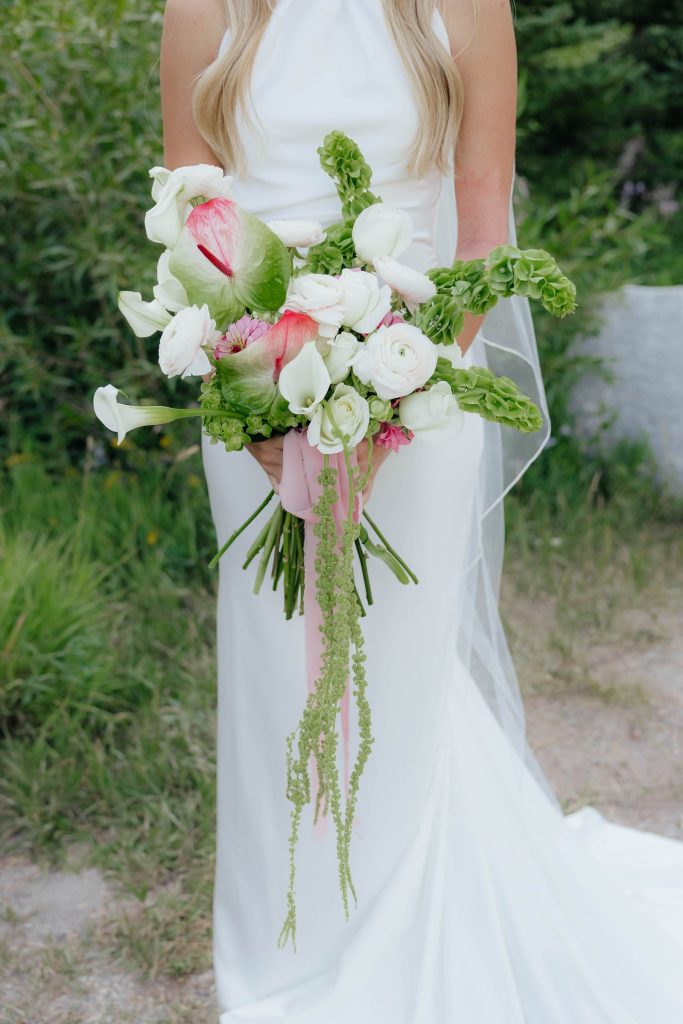 Bride holding a white and green bouquet with trailing amaranthus