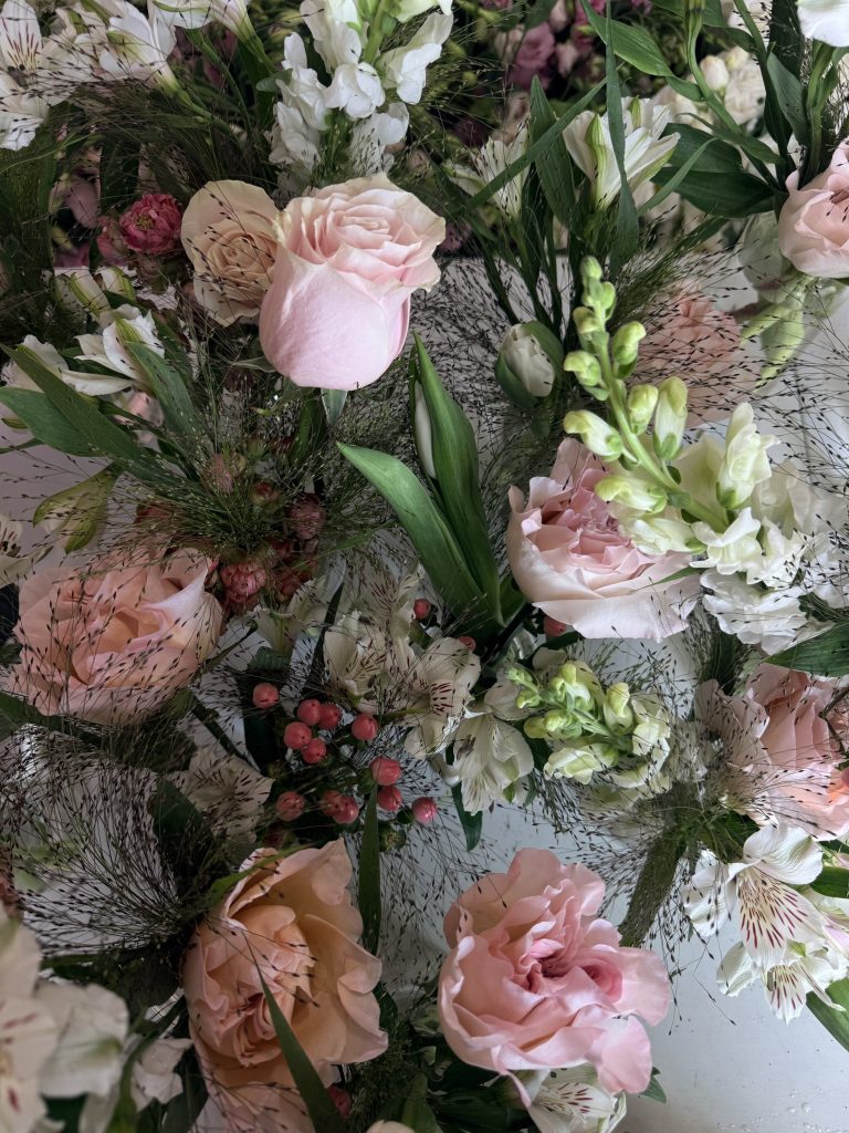 Close-up of blush garden roses, lisianthus and greenery
